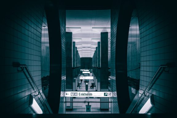 Blick in eine U-Bahn-Station mit langen, grauen Wänden und Geländern.