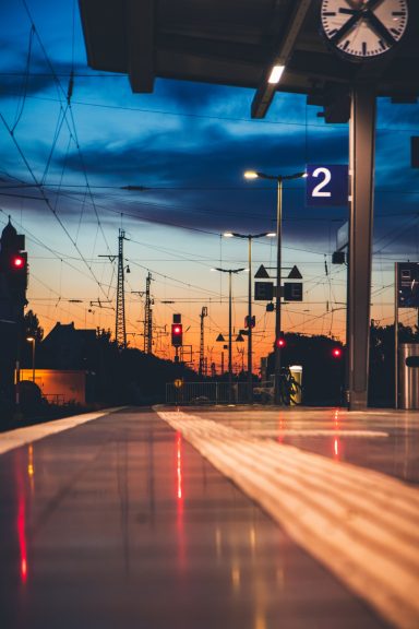 Bahnhof mit abendlichem Himmel, warten auf den Zug und zurückhaltende Beleuchtung.